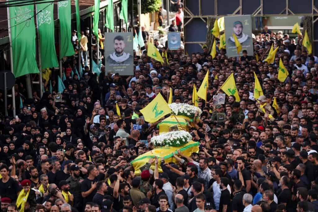 Mourners carry the coffins of Hezbollah members Fadel Abbas Bazzi and Ahmad Ali Hassan, after hand-held radios and pagers used by armed group Hezbollah detonated across Lebanon, during their funeral in Ghobeiry, Beirut southern suburbs, Lebanon September 19, 2024. (REUTERS/Emilie Madi/ Top Image)